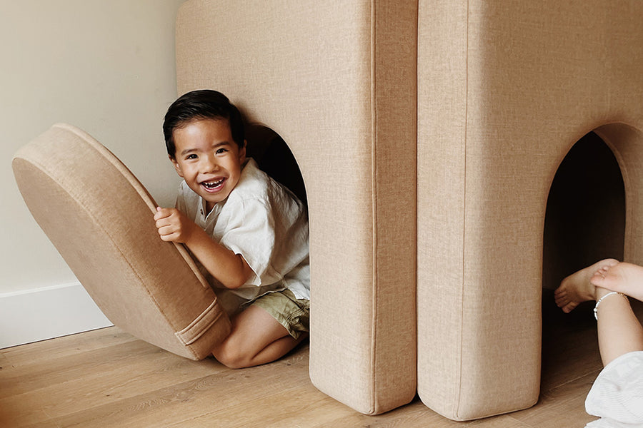 Boy peeking out from behind an arch in Camel