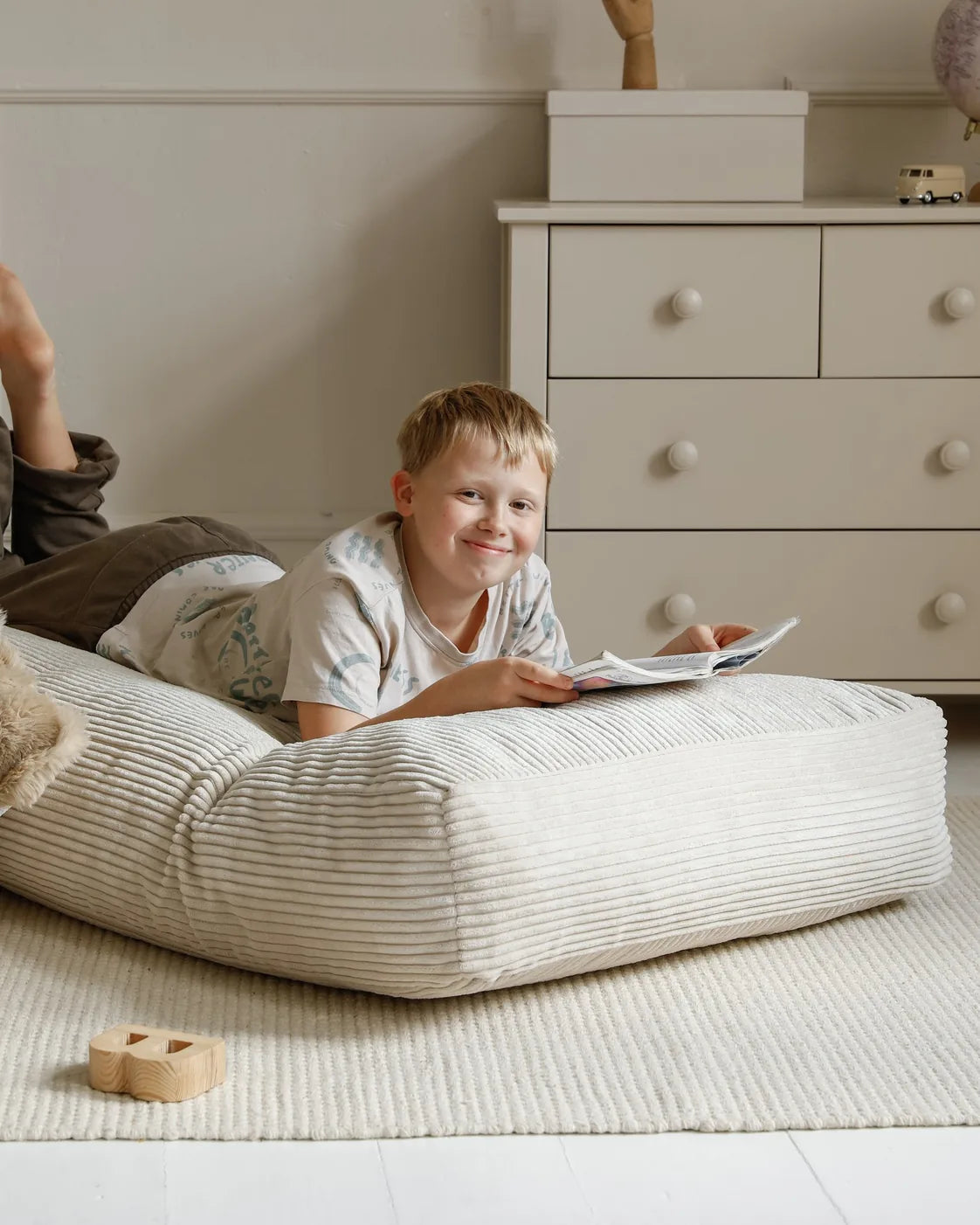 Kind steht im weichen Futon Bean Bag in Vanilla