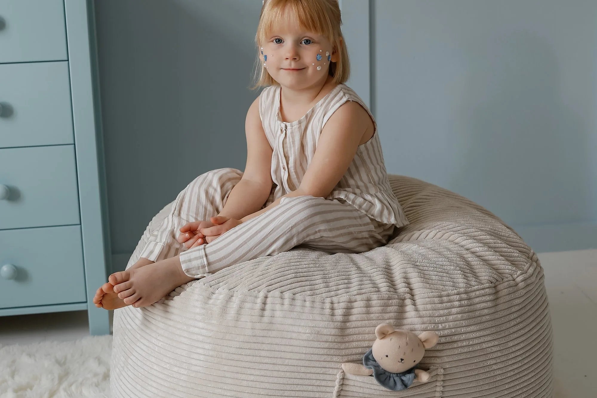 Mädchen sitzt im Futon Bean Bag in Vanilla, genutzt als Pouf