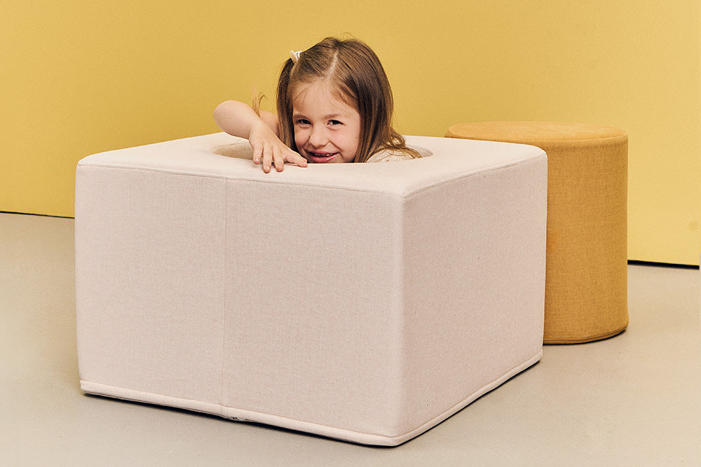 Girl peeking over the cube of the Playset