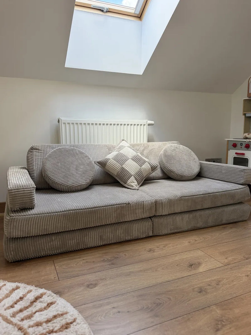 Shappy Speelbank Pure Corduroy in Mocca, opgesteld als bank onder een dakraam op een houten vloer