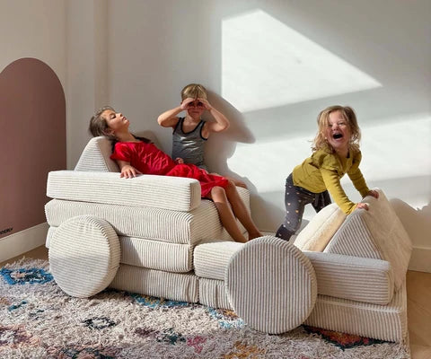 Children playing with a full-size cream corduroy SHAPPY play sofa.