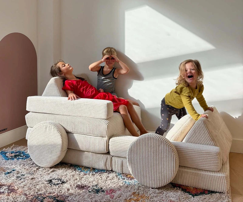 Children playing with a full-size cream corduroy SHAPPY play sofa.