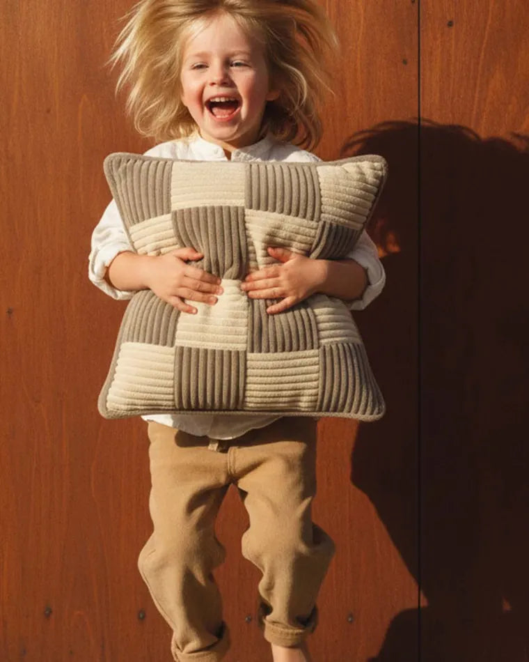 Child holding a Check Cushion