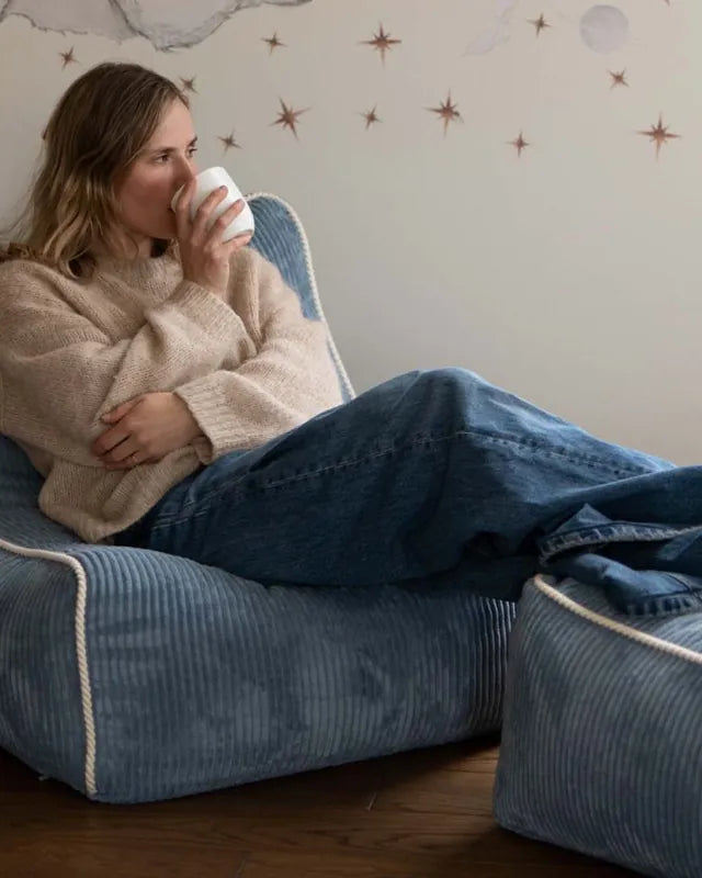 Woman relaxing in Kumo Chair Sky Sugar