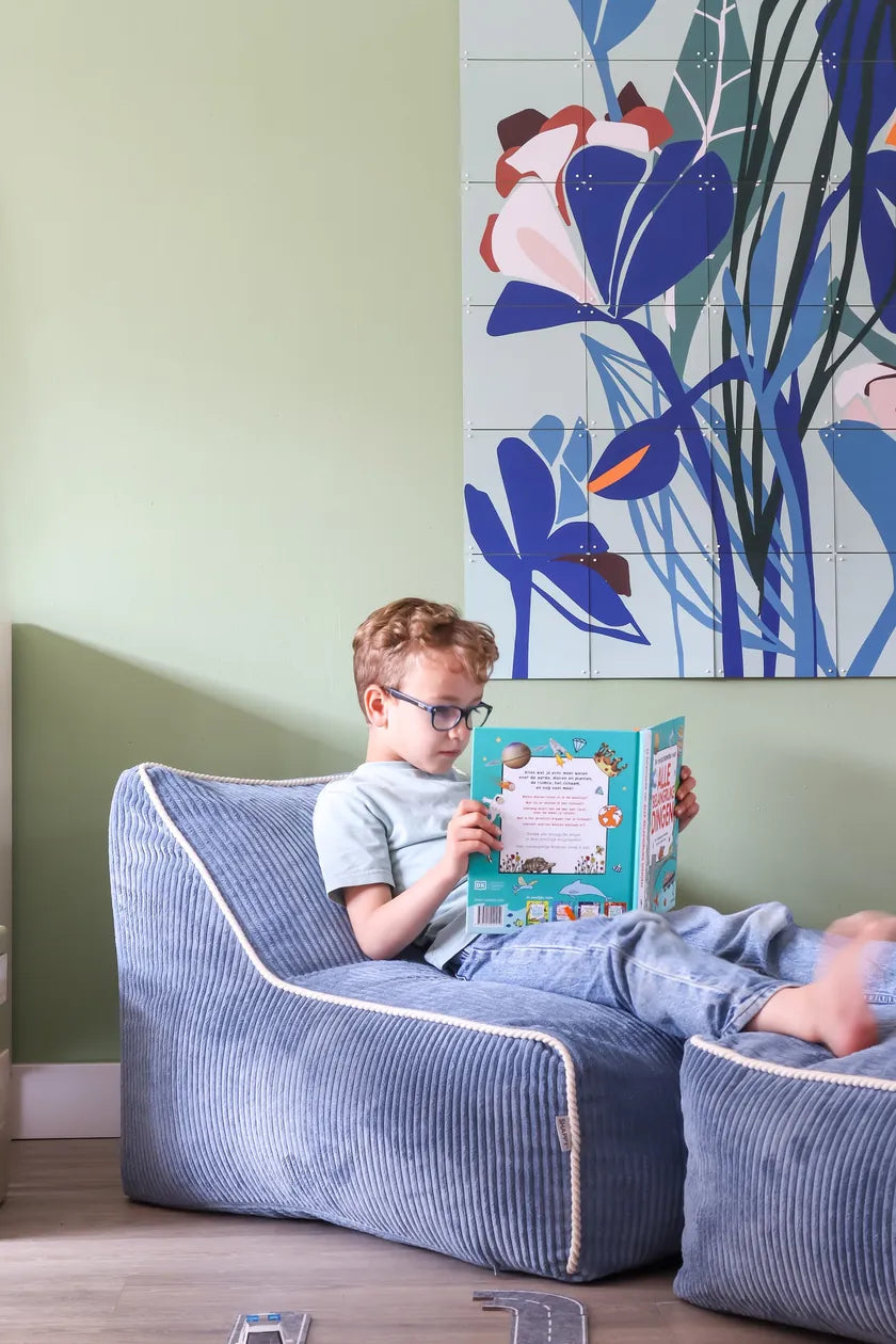 Boy reading in Kumo Chair Sky Sugar with the Ottoman