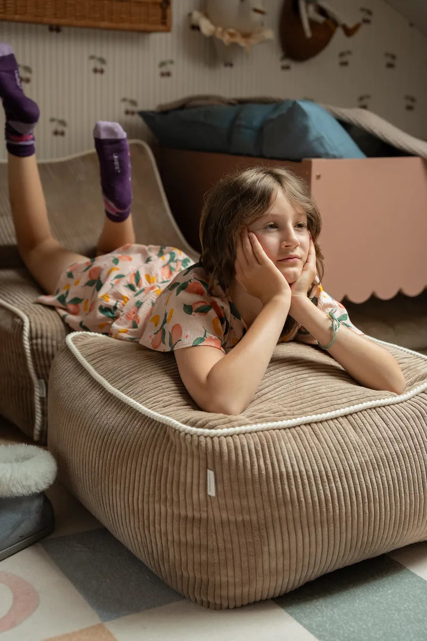 Girl lying across Kumo Ottoman and Chair