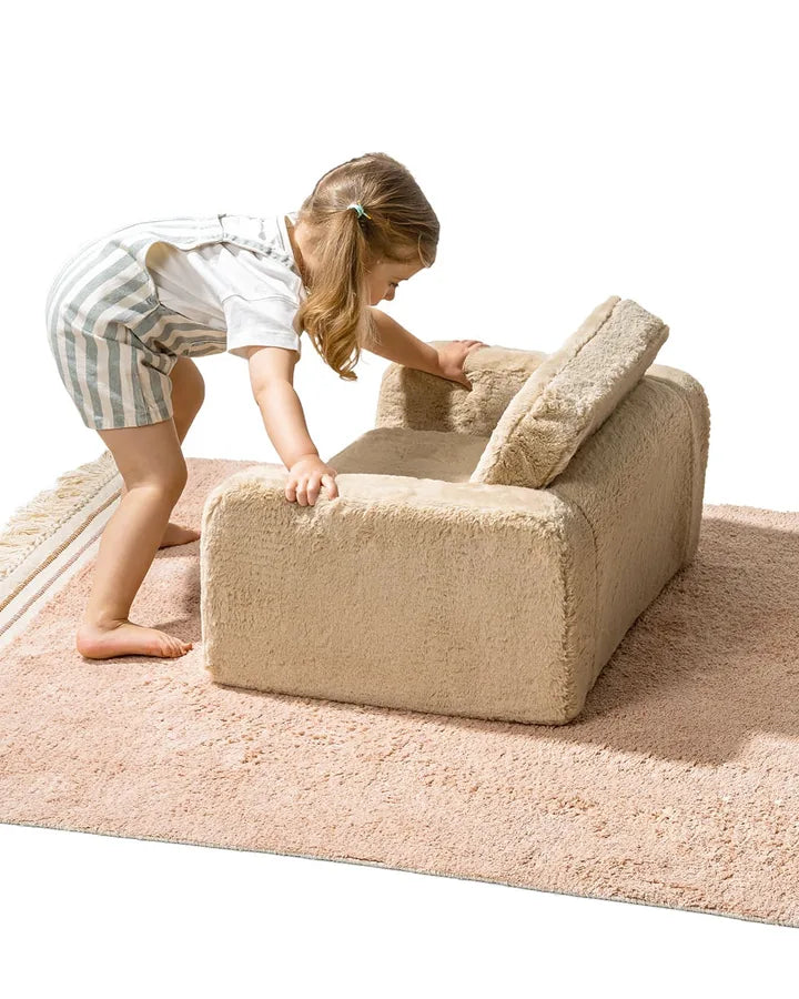 Une fille déplie le Lumi Chair Bunny coloris Toffee