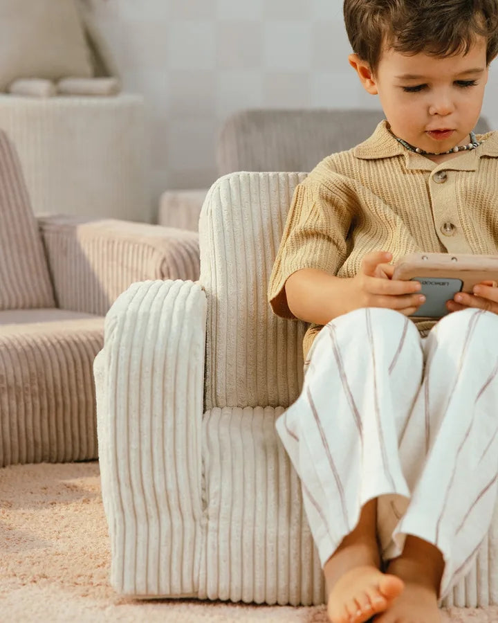 Boy sitting in Lumi Chair Corduroy in Vanilla