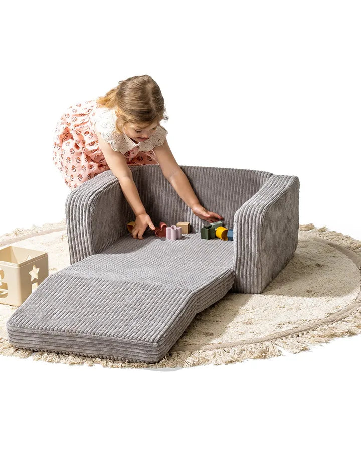 Girl playing on Lumi Chair Corduroy in Pebble, unfolded