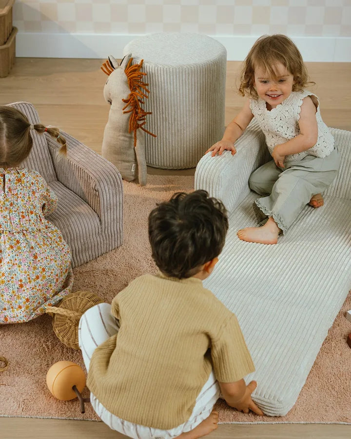 Children playing with Lumi Chair Corduroy unfolded as mats