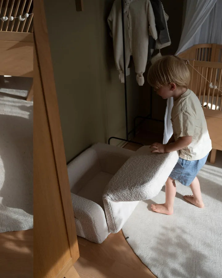 Child resting on Lumi Chair Teddy, unfolded