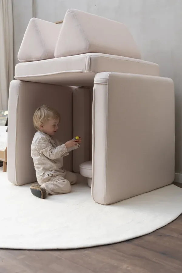 Toddler inside a little house built from Play Sofa Original Soft Beige