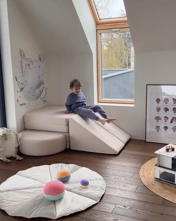 Child sliding down a Slide Original in Soft Beige