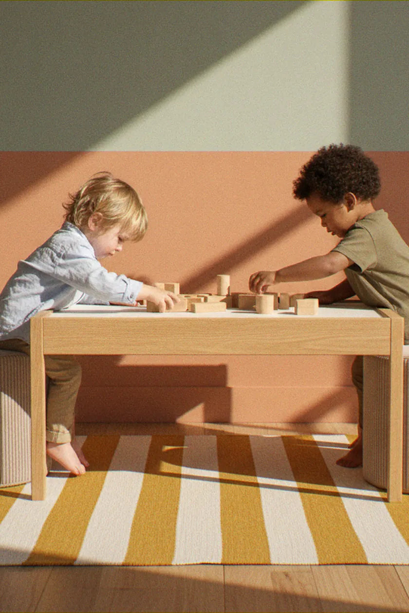 Two children playing at a table, sitting on Shappy Pouf Corduroy