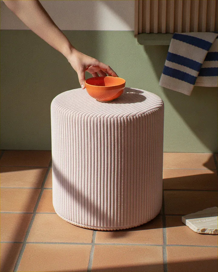 Hand placing a bowl on Shappy Pouf Corduroy Candy