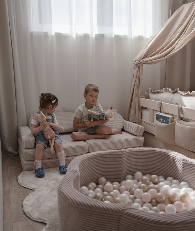 Two children sharing Play Sofa Pure Corduroy Mini in Vanilla