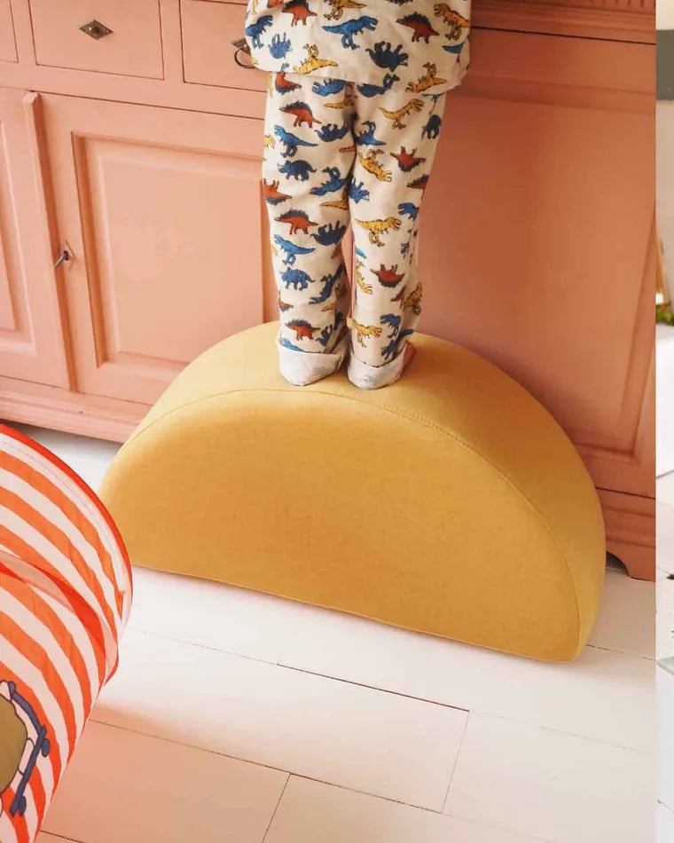 Child standing on the Rocker Ultra Plush in Mustard