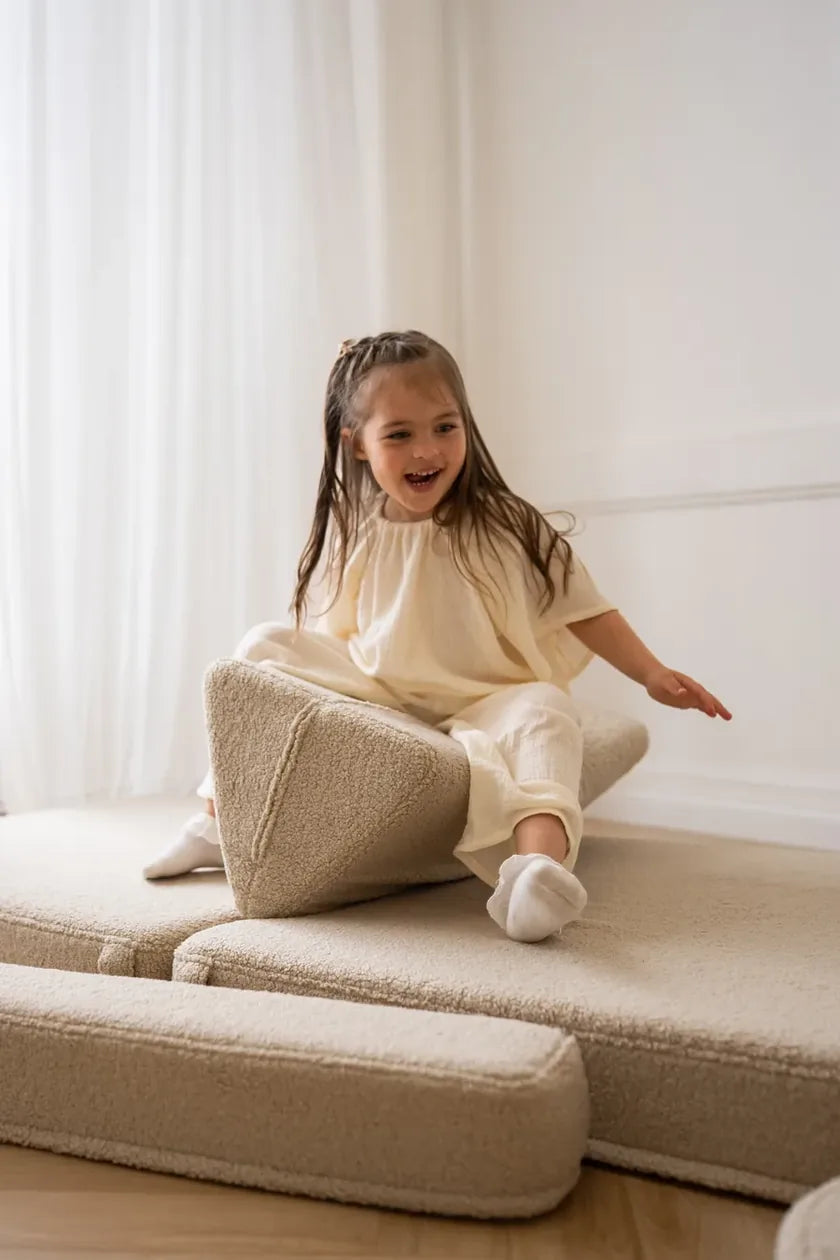 Girl sliding down a triangle cushion of Play Sofa Original Teddy