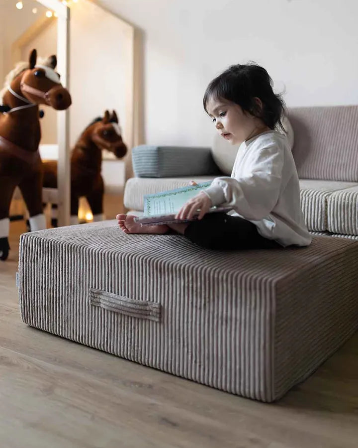 Girl sitting on Trampoline Pure Corduroy with a book