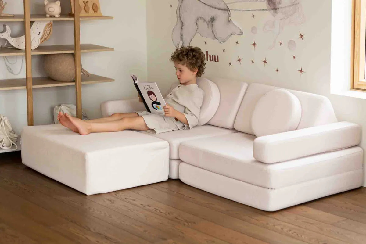 Boy reading on Play Sofa Original Soft Beige extended with the Trampoline
