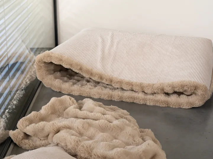 Snuggle Bag mit einem Kind darin, daneben Snuggle Blanket und Snuggle Cushion