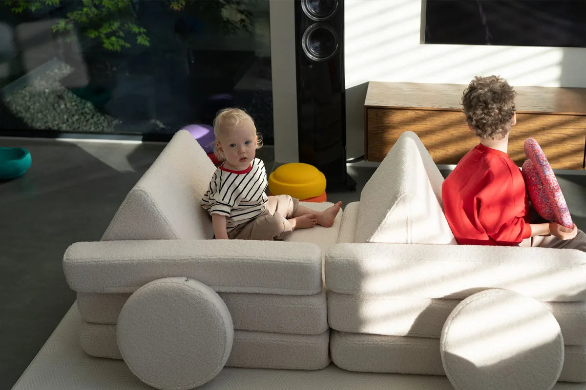 Two children playing in a car built from Play Sofa Original Teddy Soft Cream