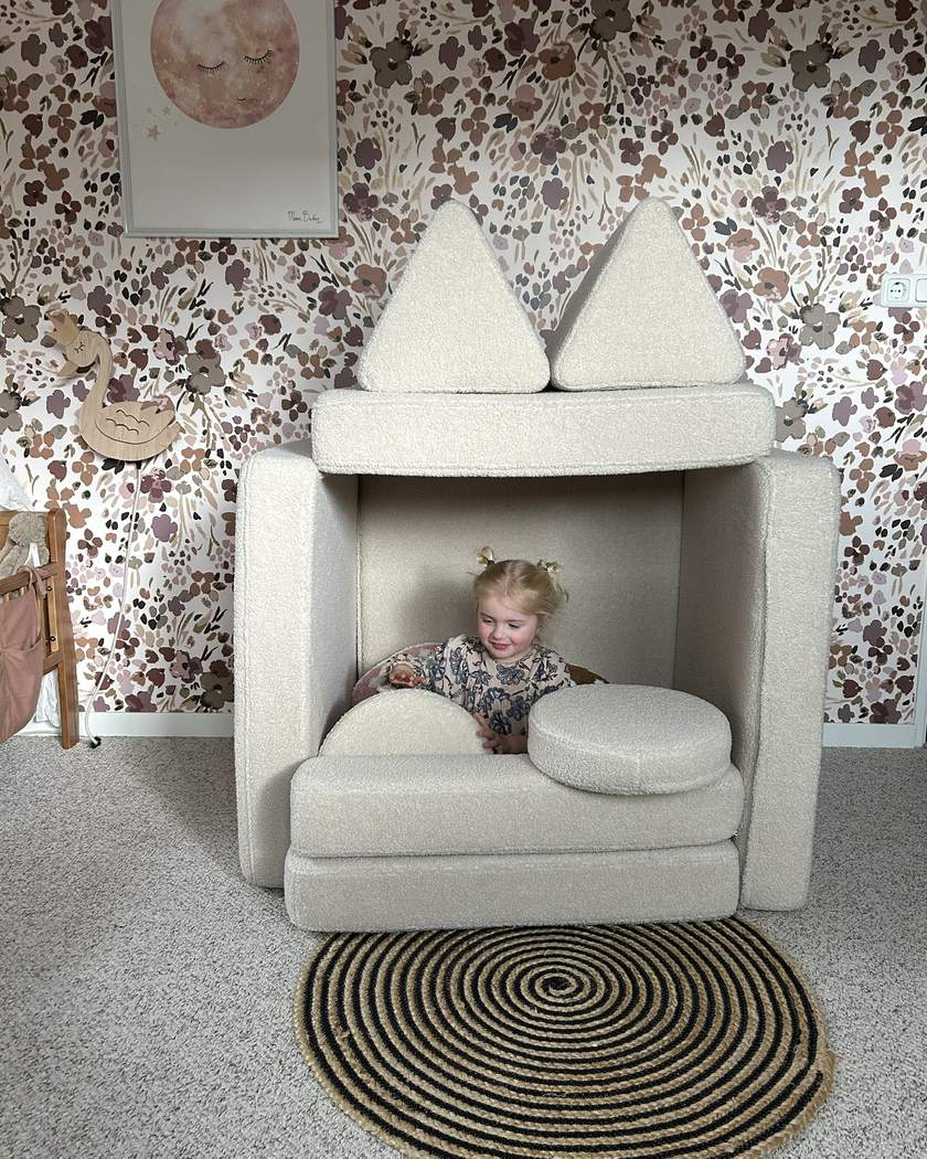 Child sitting inside a little house built from Play Sofa Original Teddy