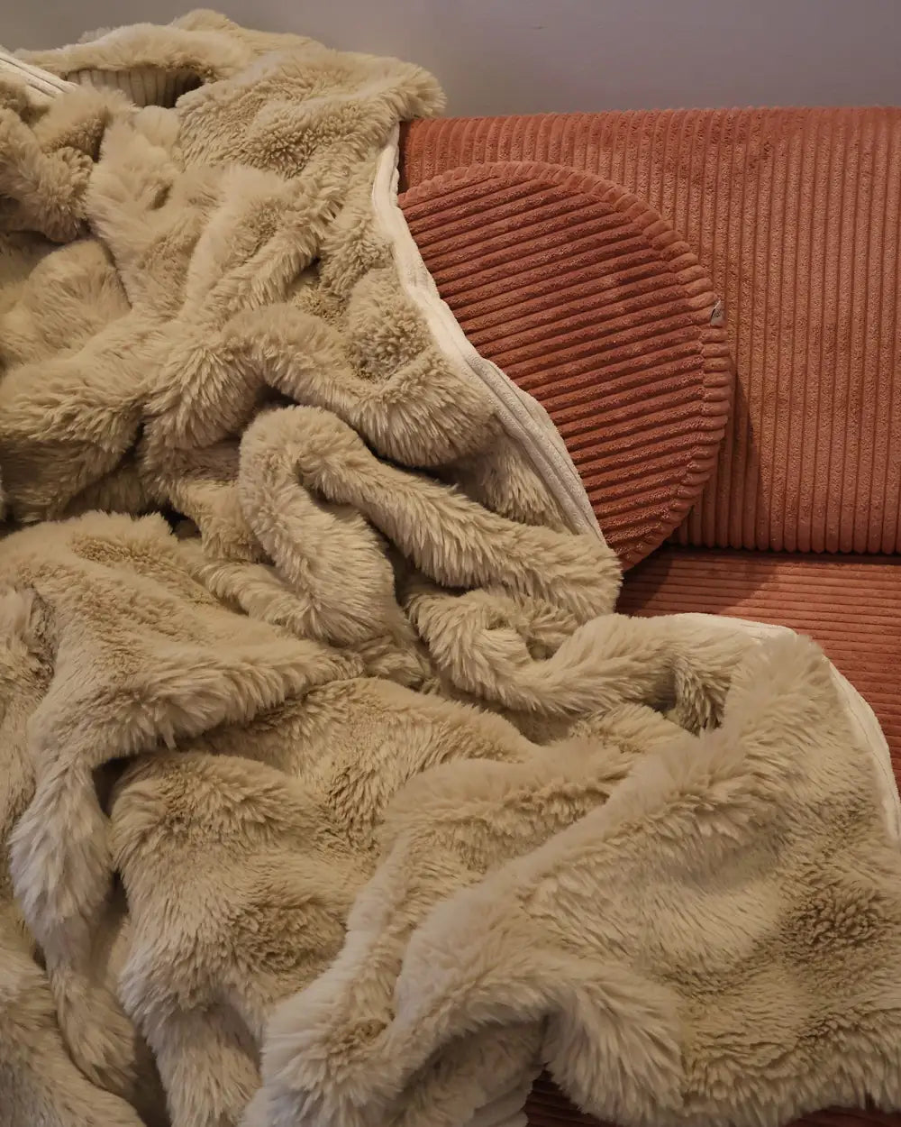 Snuggle Blanket spread on a sofa, faux fur side