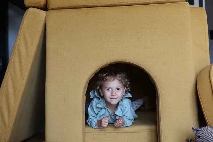 Child lying in the doorway of a castle built with Arches in Mustard