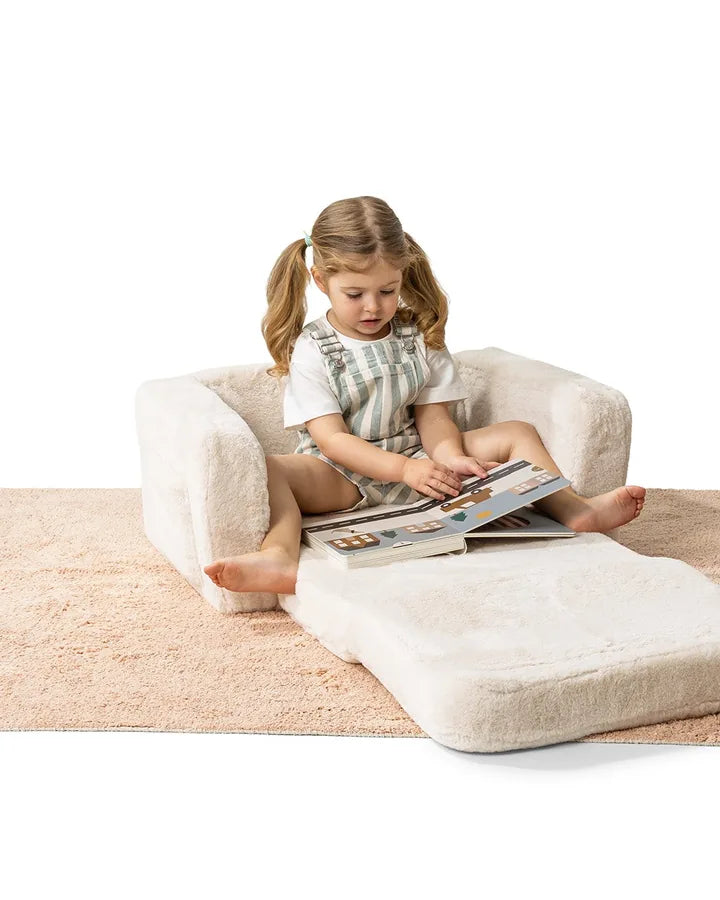 Girl reading on Lumi Chair Bunny in Cream, unfolded