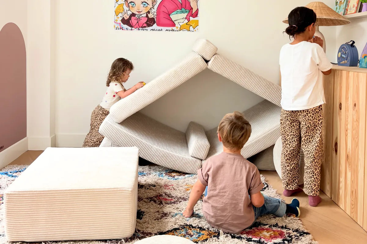 Two children sitting together on the corduroy play sofa in Vanilla