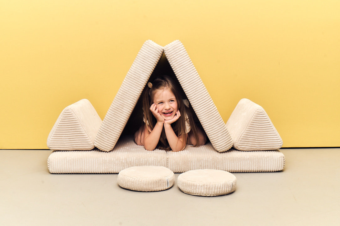 Child playing inside a den built from Play Sofa Pure Corduroy Mini in Vanilla