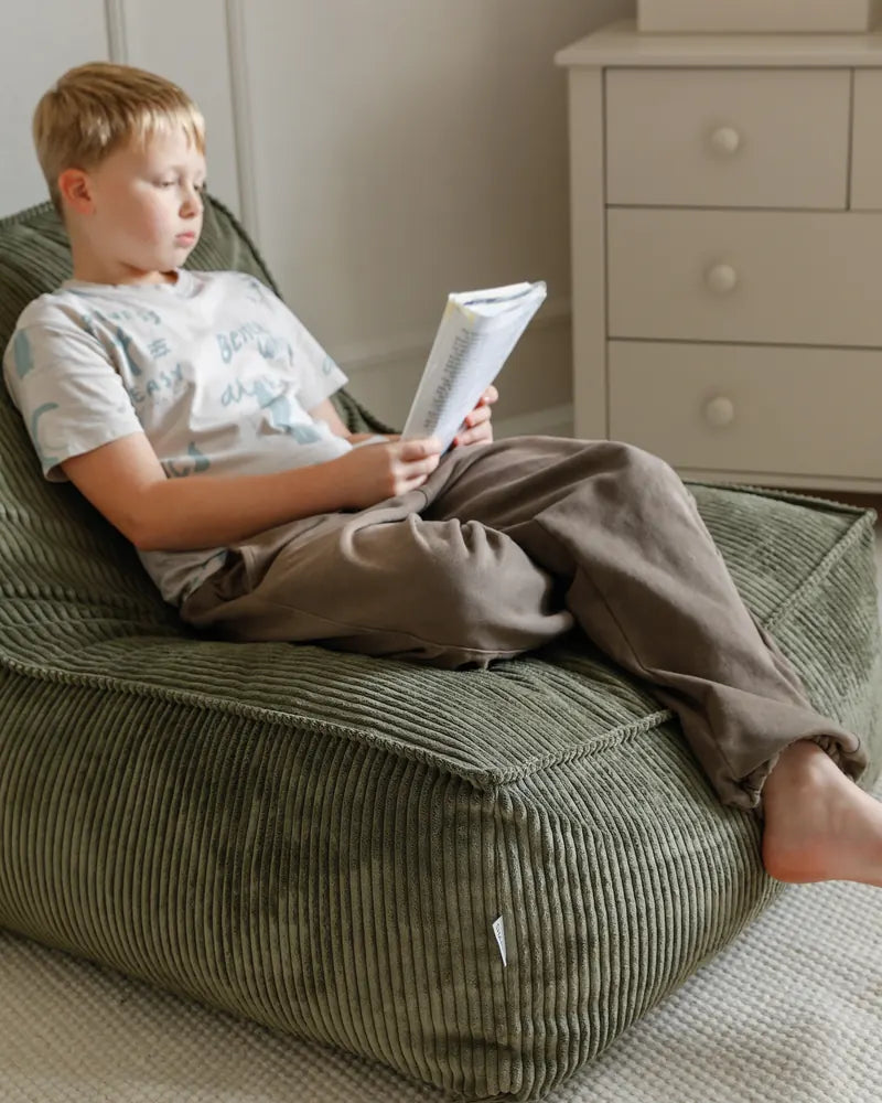 Un garçon en train de lire dans le Kumo Lounger