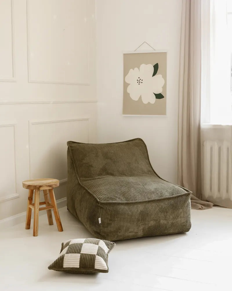 Kumo Lounger dans une pièce à côté d’un tabouret