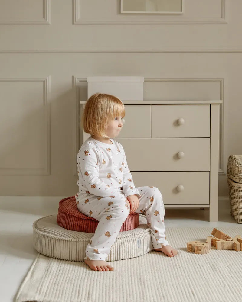 Child sitting on a Yuka Pouf Mini stacked on a Yuka Pouf