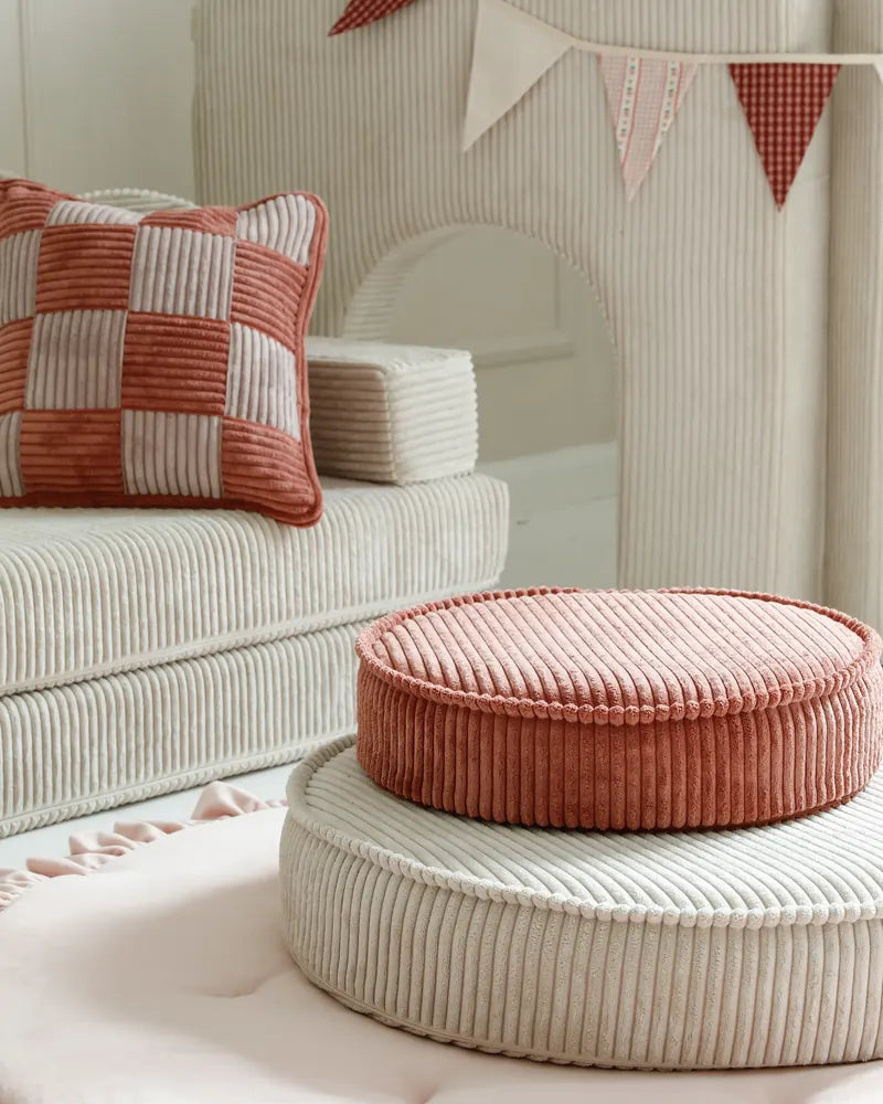 Yuka Pouf Mini in Rose on a Yuka Pouf in Vanilla in a playroom